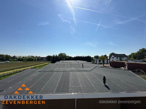 Groot plat dak met bitumen dakbedekking op bedrijfspand in Zevenbergen Groot plat dak met bitumen dakbedekking op bedrijfspand in Zevenbergen