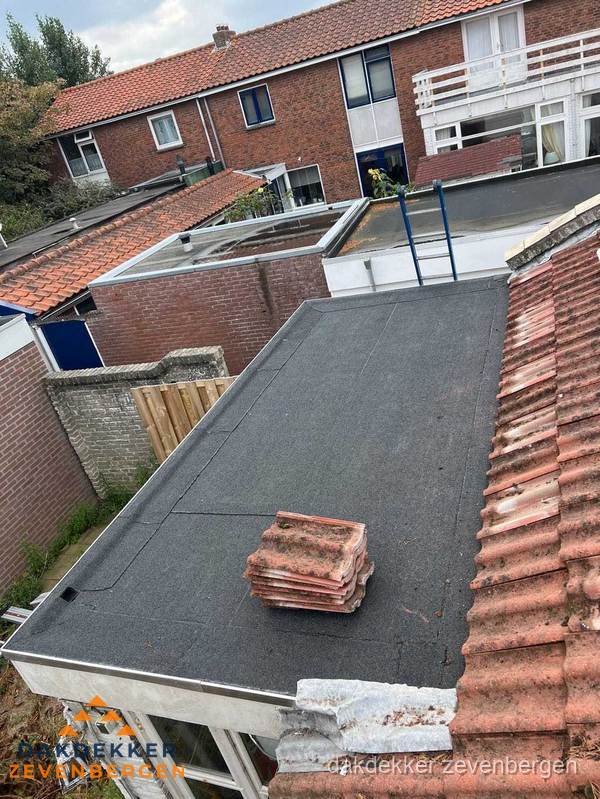 Plat dak aanbouw met bitumen naast schuin pannendak in Zevenbergen Plat dak aanbouw met bitumen naast schuin pannendak in Zevenbergen