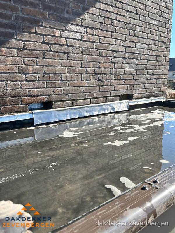 Stilstaand water op plat dak door slechte afwatering in Zevenbergen Stilstaand water op plat dak door slechte afwatering in Zevenbergen