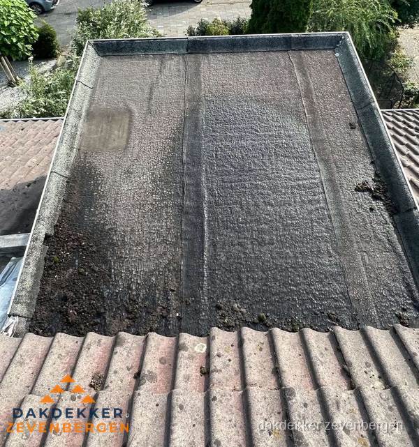 Verouderd plat dak met bitumen en slijtage voor lekkage inspectie in Zevenbergen Verouderd plat dak met bitumen en slijtage voor lekkage inspectie in Zevenbergen