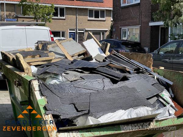 Afvalcontainer met gesloopt dakmateriaal tijdens dakkapel renovatie in Zevenbergen Afvalcontainer met gesloopt dakmateriaal tijdens dakkapel renovatie in Zevenbergen