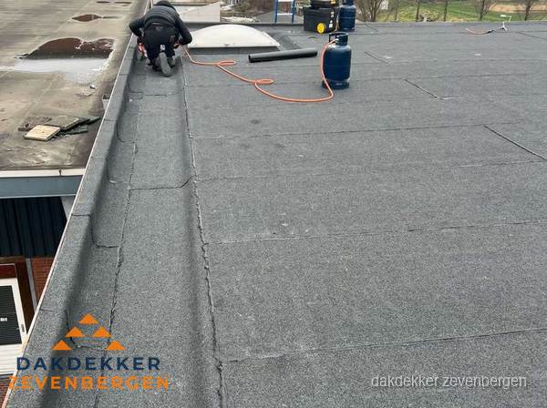 Dakdekker repareert bitumen dakbedekking op groot plat dak in Zevenbergen Dakdekker repareert bitumen dakbedekking op groot plat dak in Zevenbergen