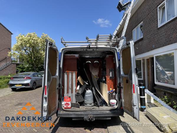 Spoed dakdekker bus met gereedschap en ladder bij woning in Zevenbergen
